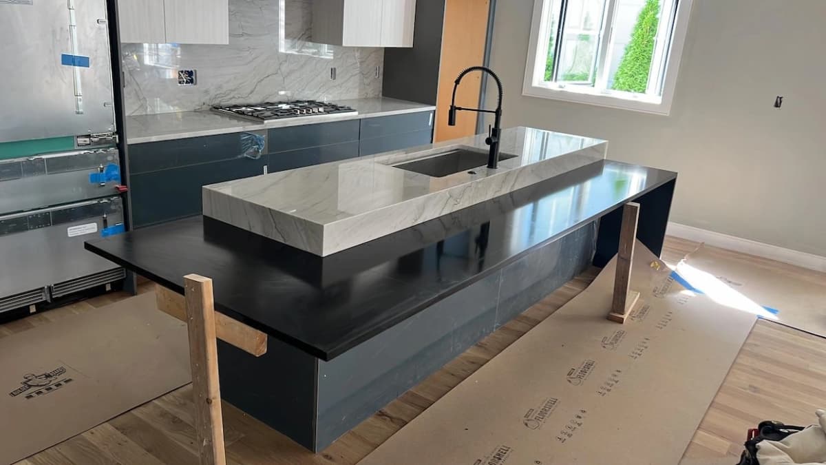 Black granite island paired with marble perimeter countertops